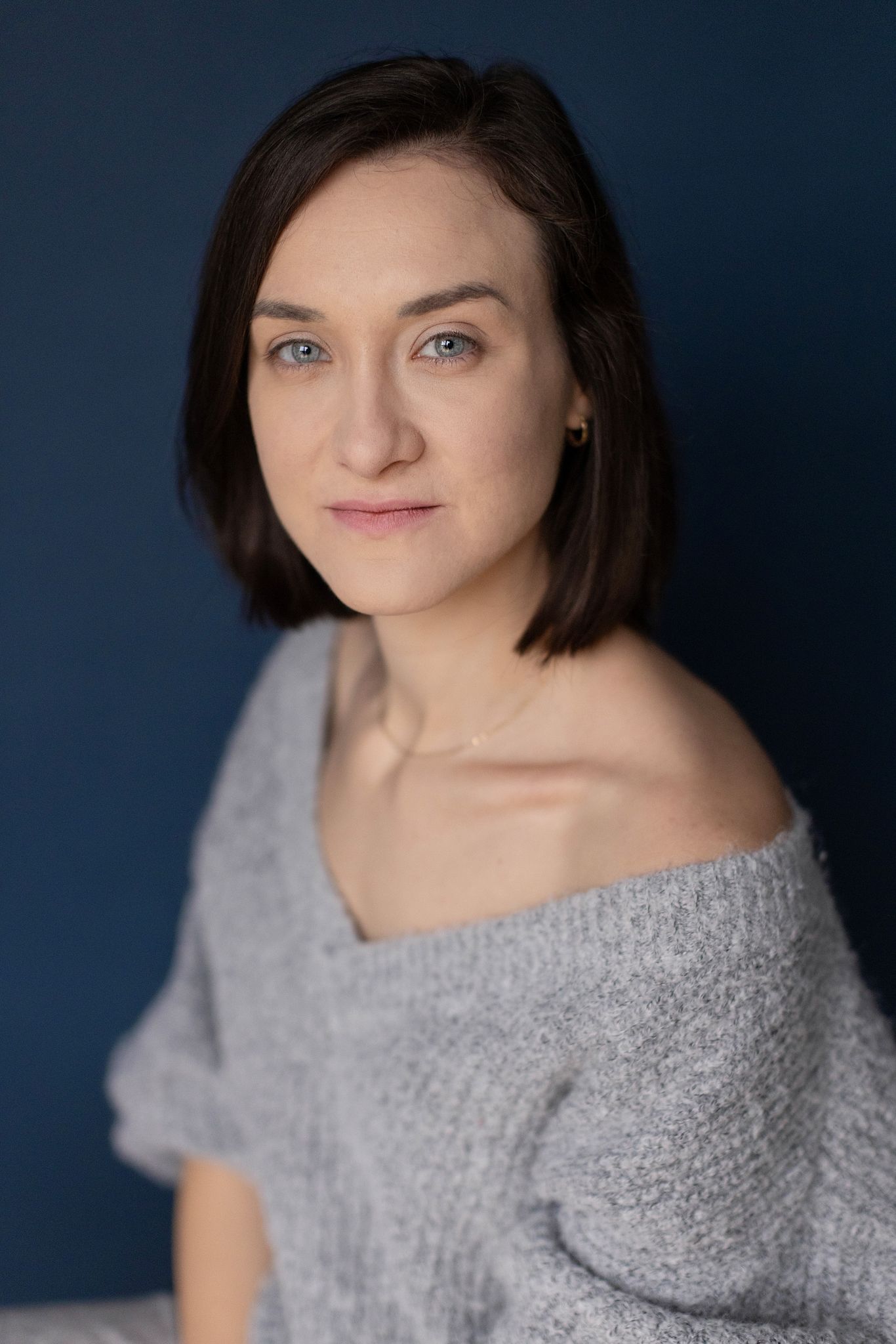 Magdalena Tarnawska-Stus - portret w białym topie i jeansach, neutralne tło