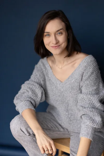 Magdalena Tarnawska-Stus - portret centralny, ręce skrzyżowane, biały top i jeansy