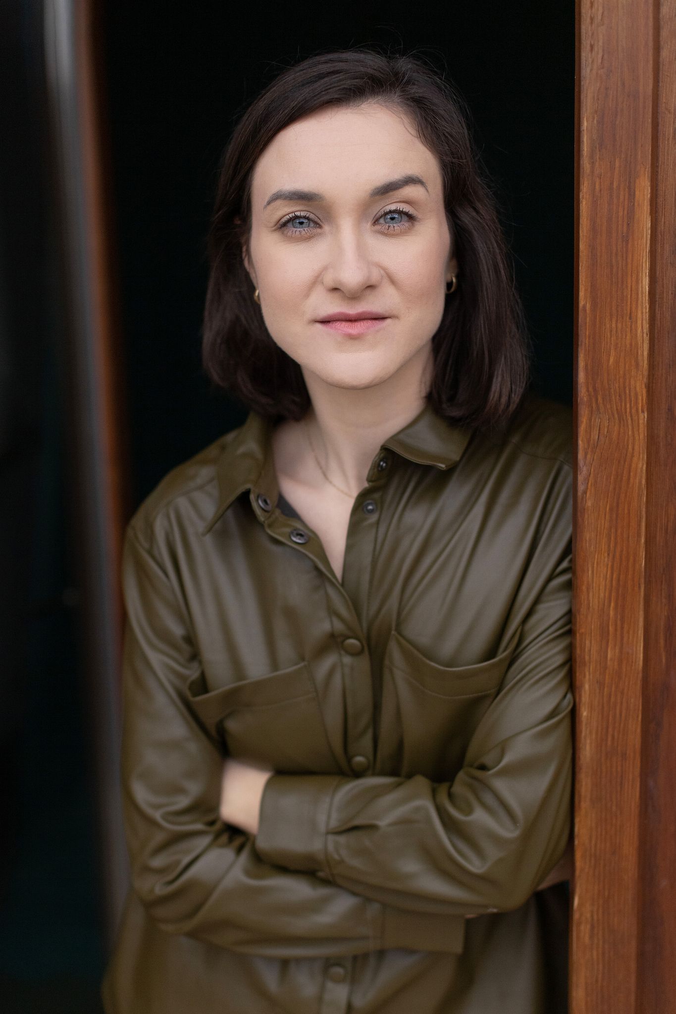 Magdalena Tarnawska-Stus - pełna sylwetka w jasnej sukience, szara fakturowa ściana