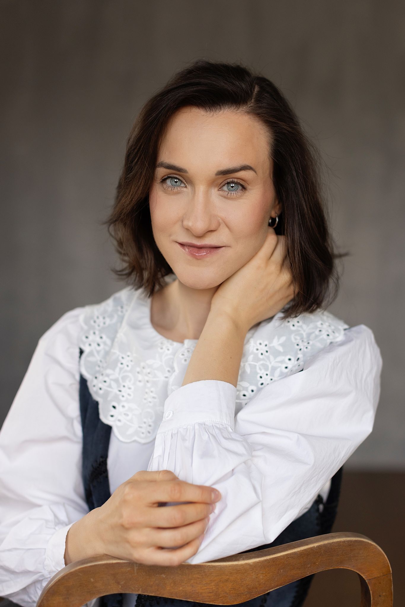 Magdalena Tarnawska-Stus - portret w szarym swetrze, ciemnoniebieskie tło